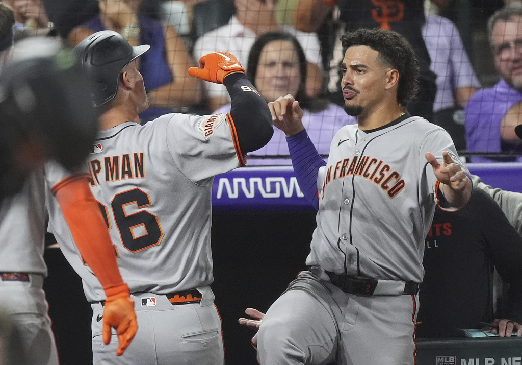 San Francisco Giants' Willy Adames, right, congratulates Matt Chapman as he returns to the dugout after hitting a three-run home run off Colorado Rockies relief pitcher Juan Mejia in the sixth inning of a baseball game Wednesday, Sept. 3, 2025, in Denver. (AP Photo/David Zalubowski)
