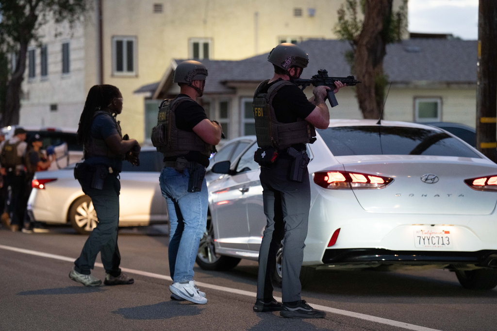 FBI agents take positions outside the home of Lakiya Malone, who is charged with fraud involving federal homelessness aid programs, in Los Angeles, Wednesday, Sept. 16, 2026. (AP Photo/Jae C. Hong)