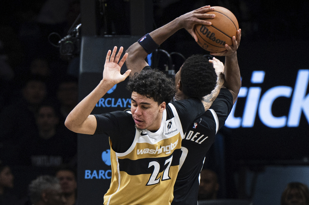 Washington Wizards guard Will Riley (27) gets his arm stuck with Brooklyn Nets forward E.J. Liddell (9) during the second half of an NBA basketball game, Sunday, April 5, 2026, in New York. (AP Photo/Angelina Katsanis)