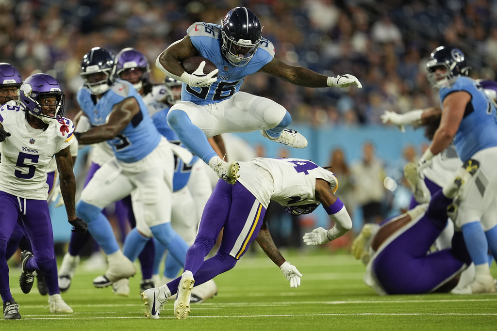 Tennessee Titans running back Julius Chestnut (36) leaps over Minnesota Vikings safety Jay Ward (24) during the first half of a preseason NFL football game, Friday, Aug. 22, 2025, in Nashville, Tenn. (AP Photo/George Walker IV)