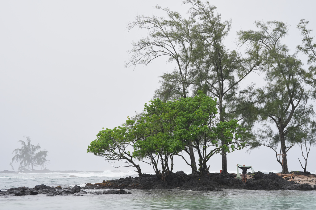 Kawika Ige fishes as Hurricane Nolo sits nearby Friday, Sept. 25, 2026, in Hilo, Hawaii. (AP Photo/Gregory Bull)