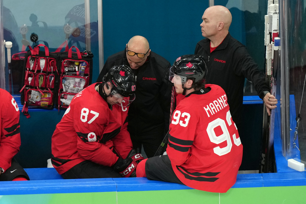 Canada's Sidney Crosby (87) is attended to after being injured during the second period of a men's ice hockey quarterfinal game between Canada and Czechia at the 2026 Winter Olympics, in Milan, Italy, Wednesday, Feb. 18, 2026. (AP Photo/Hassan Ammar)