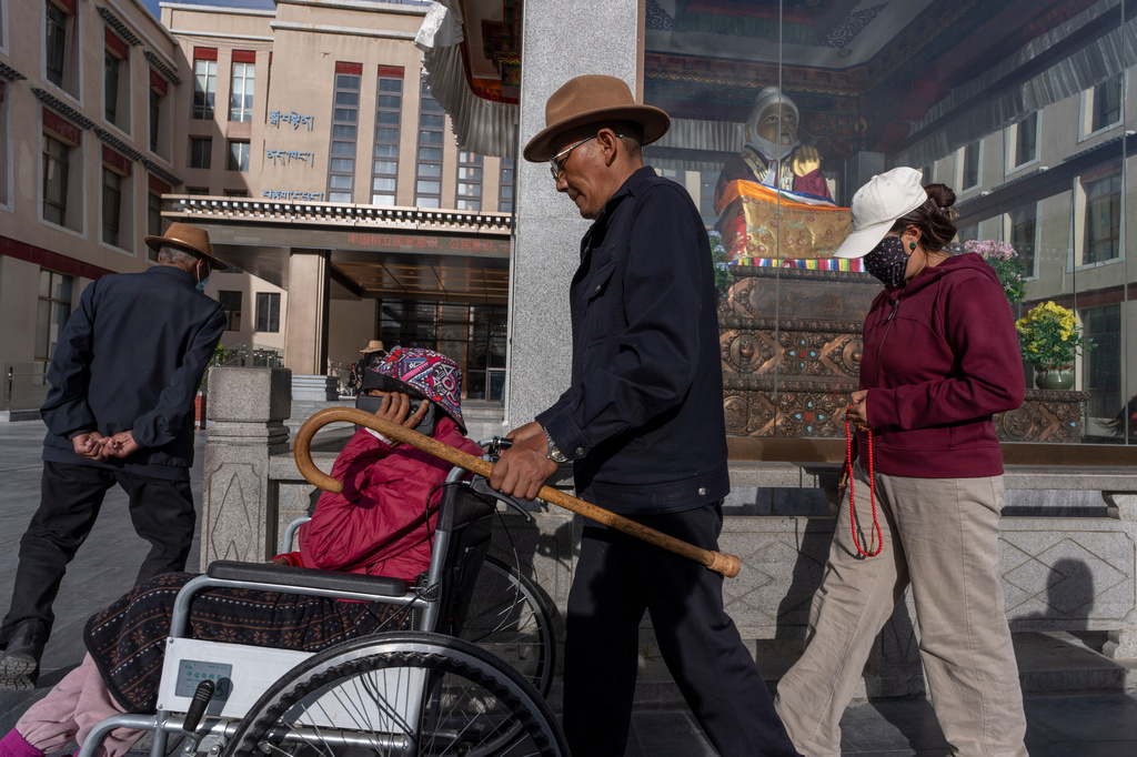 Locals perform circumambulations around a statue of Tibetan medical master Yutok Nyingma Yonten Gonpo outside the Xizang Autonomous Region Hospital of Tibetan Medicine in Lhasa, in western China's Tibet Autonomous Region on Wednesday, July 22, 2026 as seen during a government organized visit for foreign journalists. (AP Photo/Ng Han Guan)