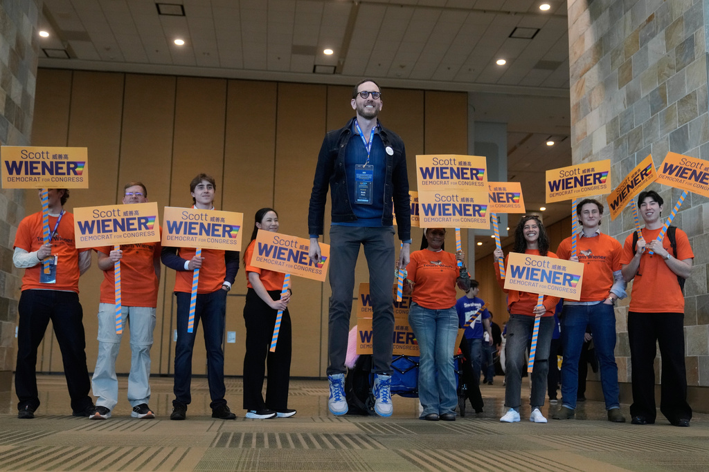 State Sen. Scott Wiener, center, jumps up while taking photos with supporters at the 2026 California Democratic Party State Convention in San Francisco, Saturday, Feb. 21, 2026. (AP Photo/Jeff Chiu)