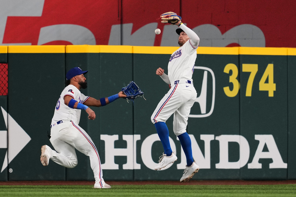 Texas Rangers right fielder Brandon Nimmo, right, misplays the ball that allowed New York Mets' Francisco Alvarez to reach second and Carson Benge to score as center fielder Ezequiel Duran, left, looks on in the fourth inning of a baseball game Tuesday, Sept. 22, 2026, in Arlington, Texas. (AP Photo/Tony Gutierrez)
