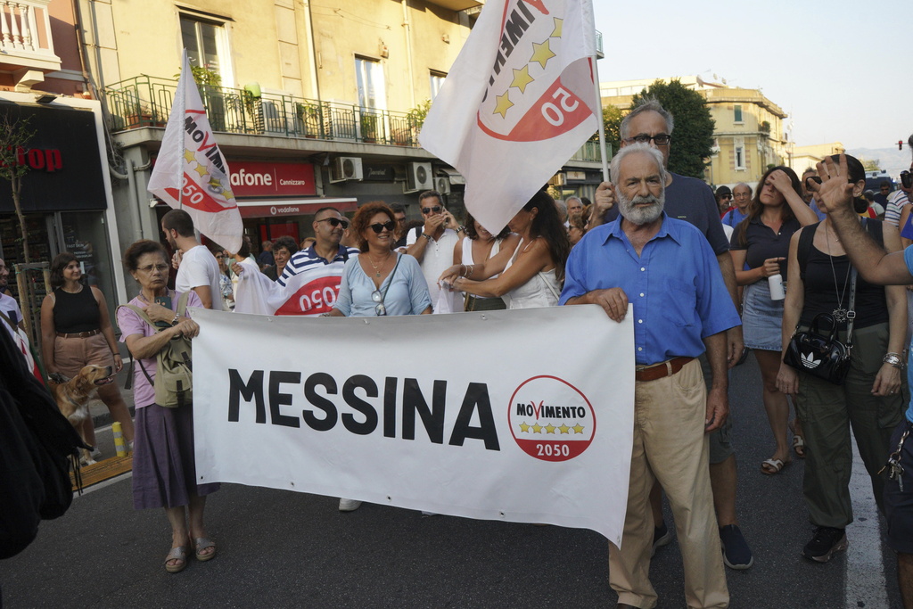 People hold a banner during a demonstration against the bridge in Messina, Italy on Saturday, Aug. 9, 2025 (Francesco Saya/LaPresse via AP)