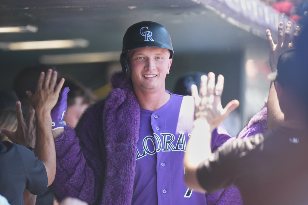 Colorado Rockies' TJ Rumfield is congratulated as he returns to the dugout after hitting a two-run home run off Cincinnati Reds relief pitcher Caleb Ferguson in the sixth inning of a baseball game Saturday, July 18, 2026, in Denver. (AP Photo/David Zalubowski)