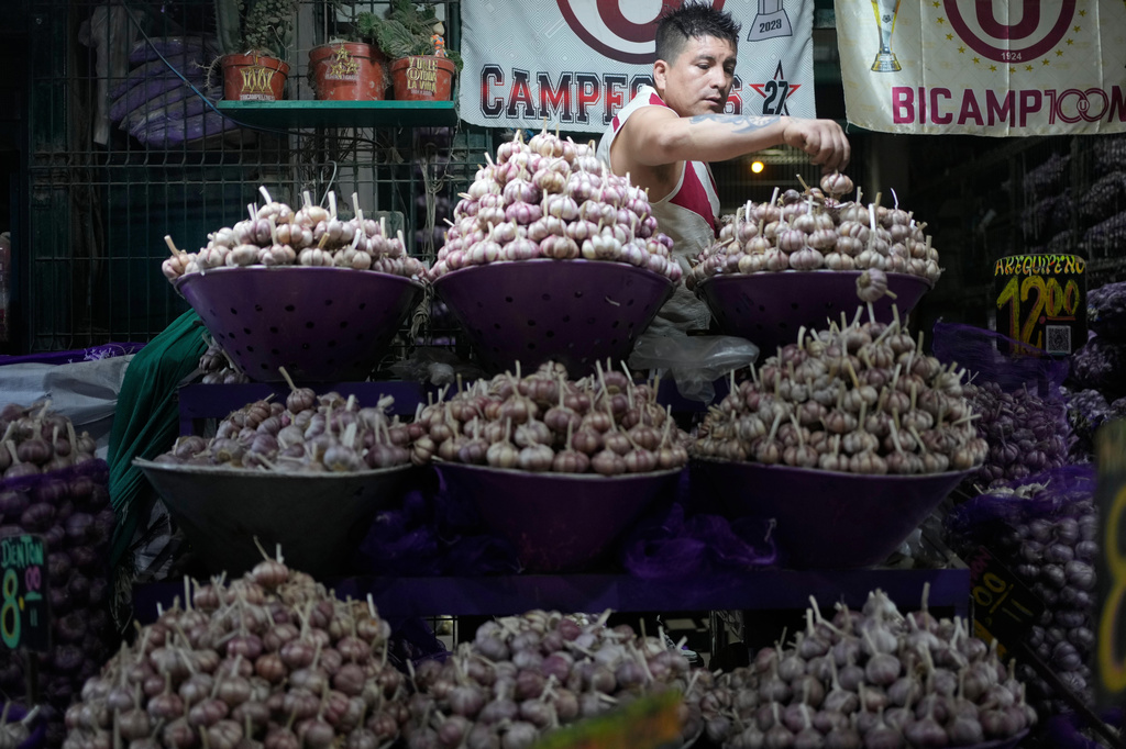 FILE - A vendor stacks garlic for sale at a produce market in Lima, Peru, May 12, 2026. (AP Photo/Martin Mejia, File)