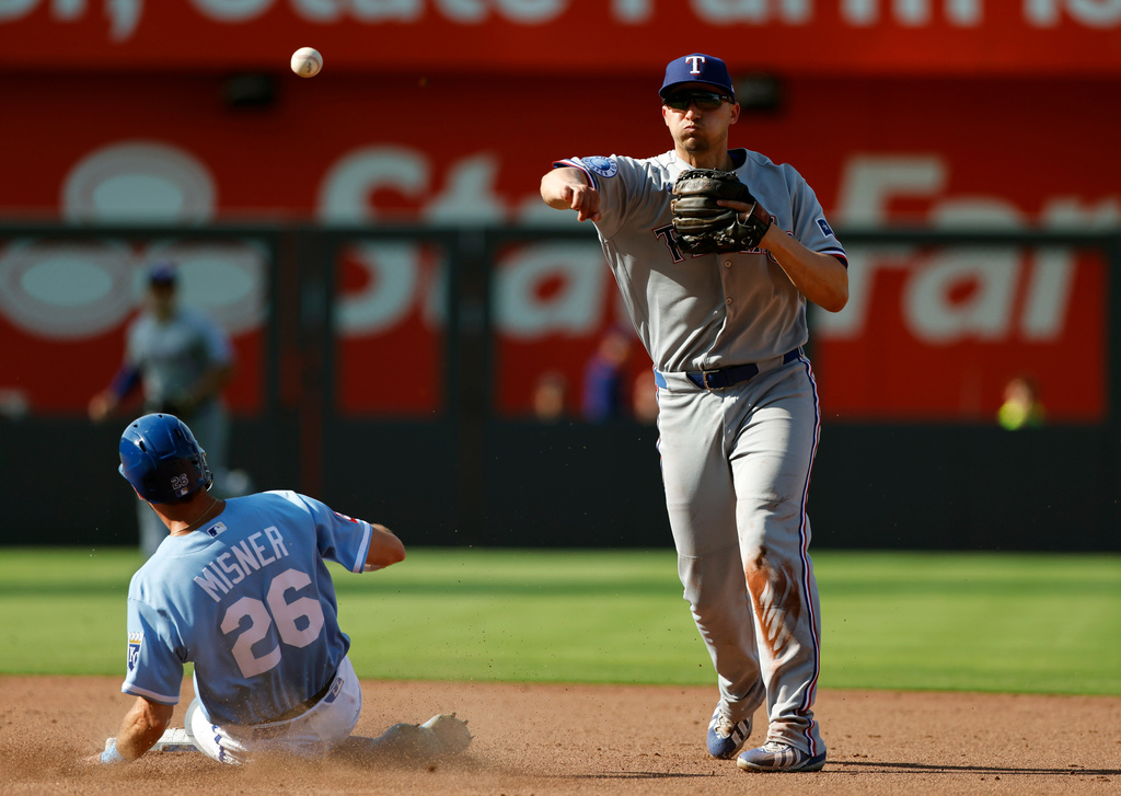 Kansas City Royals' Kameron Misner (26) is out at second base as Texas Rangers shortstop Corey Seager, right, throws to first base for a double play during the seventh inning of a baseball game in Kansas City, Mo., Thursday, June 11, 2026. (AP Photo/Colin E. Braley)