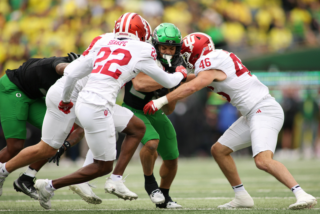 Oregon running back Jayden Limar, second from right, runs the ball while defended by Indiana defensive back Jamari Sharpe (22) and linebacker Isaiah Jones (46) during the first half of an NCAA college football game, Saturday, Oct. 11, 2025, in Eugene, Ore. (AP Photo/Lydia Ely)