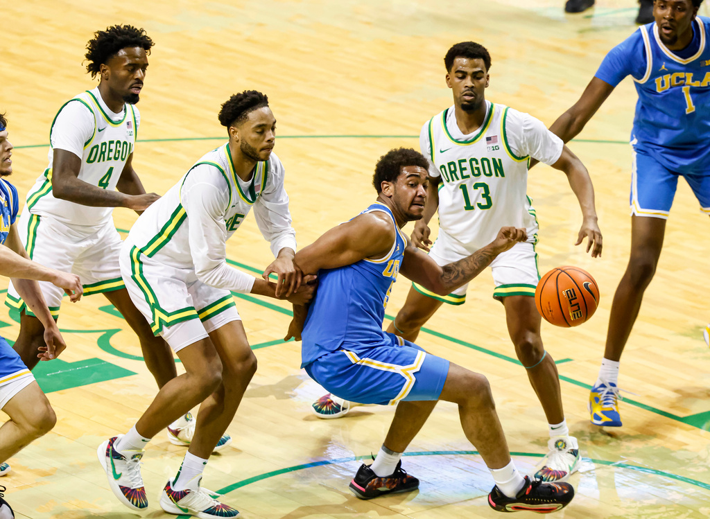 Oregon forward Kwame Evans Jr. (10) and UCLA guard Brandon Williams (5) fight for a loose ball in the first half of an NCAA college basketball game in Eugene, Ore., Wednesday, Jan. 28, 2026. (AP Photo/Thomas Boyd)