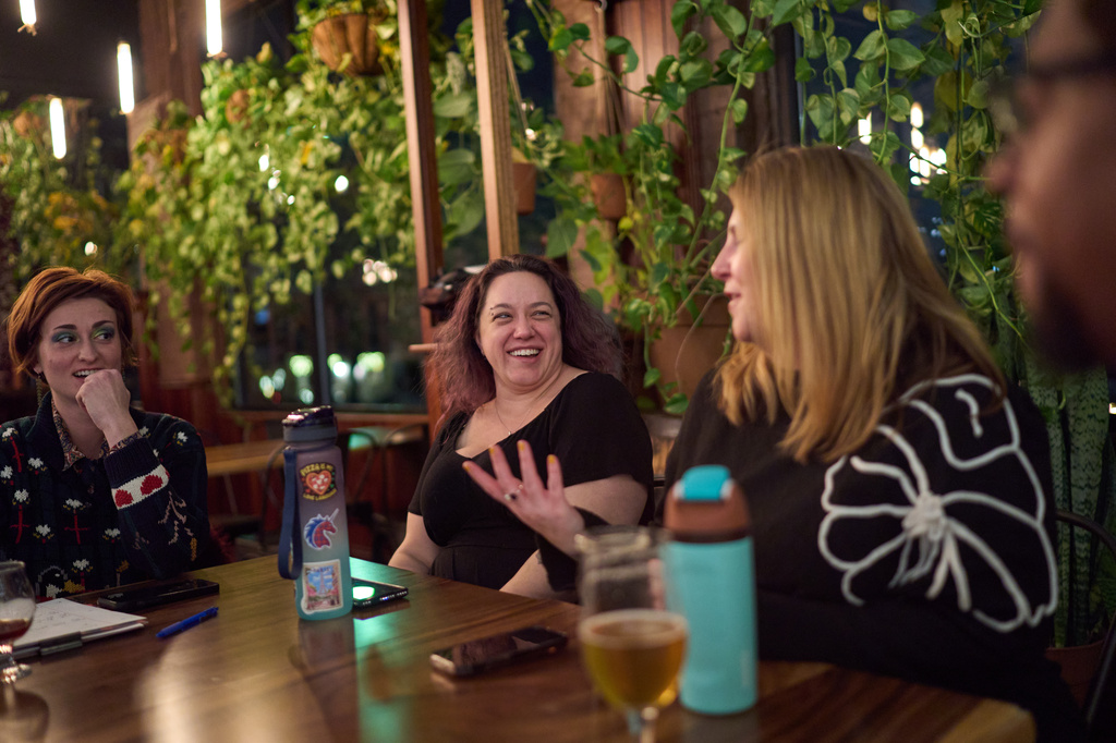 Jean Booth, second from left, who was targeted by a romance scam, attends a trivia night with friends in Lakewood, Ohio, Dec. 9, 2025. (AP Photo/David Goldman)