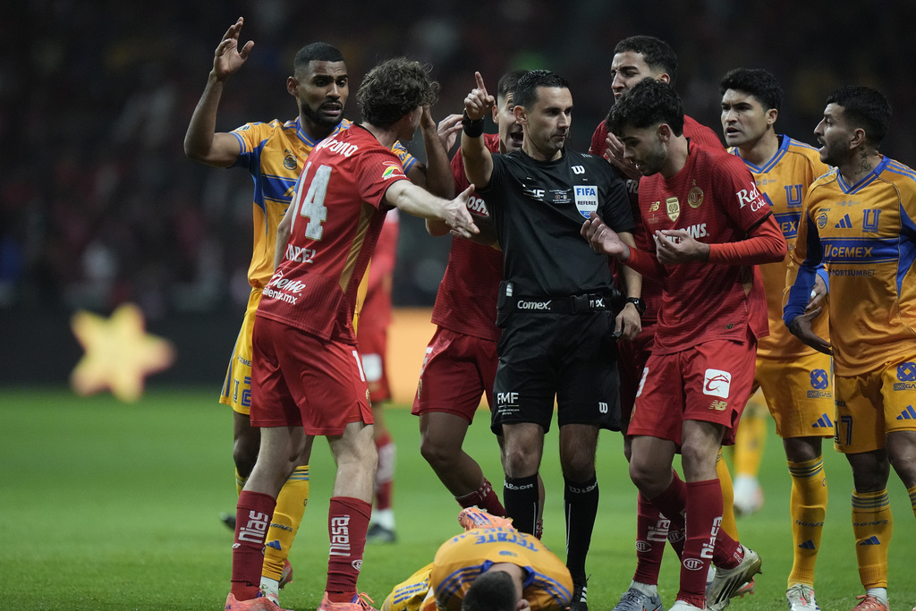 Players of Toluca and Tigres protest referee Cesar Ramos during the Mexican soccer league second leg final match in Toluca, Mexico, Sunday, Dec. 14, 2025. (AP Photo/Eduardo Verdugo)