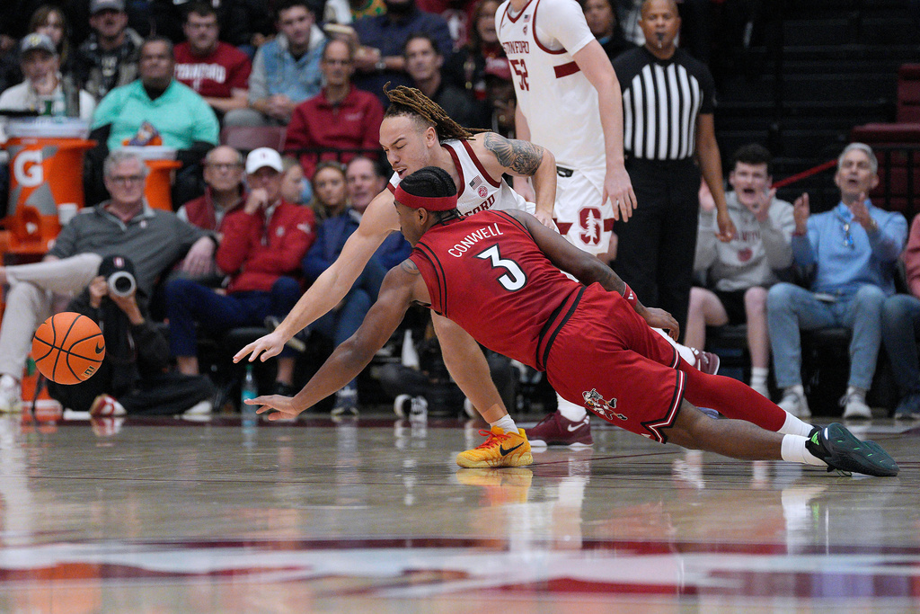 Stanford guard Jeremy Dent-Smith battles for a loose ball against Louisville guard Ryan Conwell (3) during the first half of an NCAA college basketball game in Stanford, Calif., Friday, Jan. 2, 2026. (AP Photo/Tony Avelar)