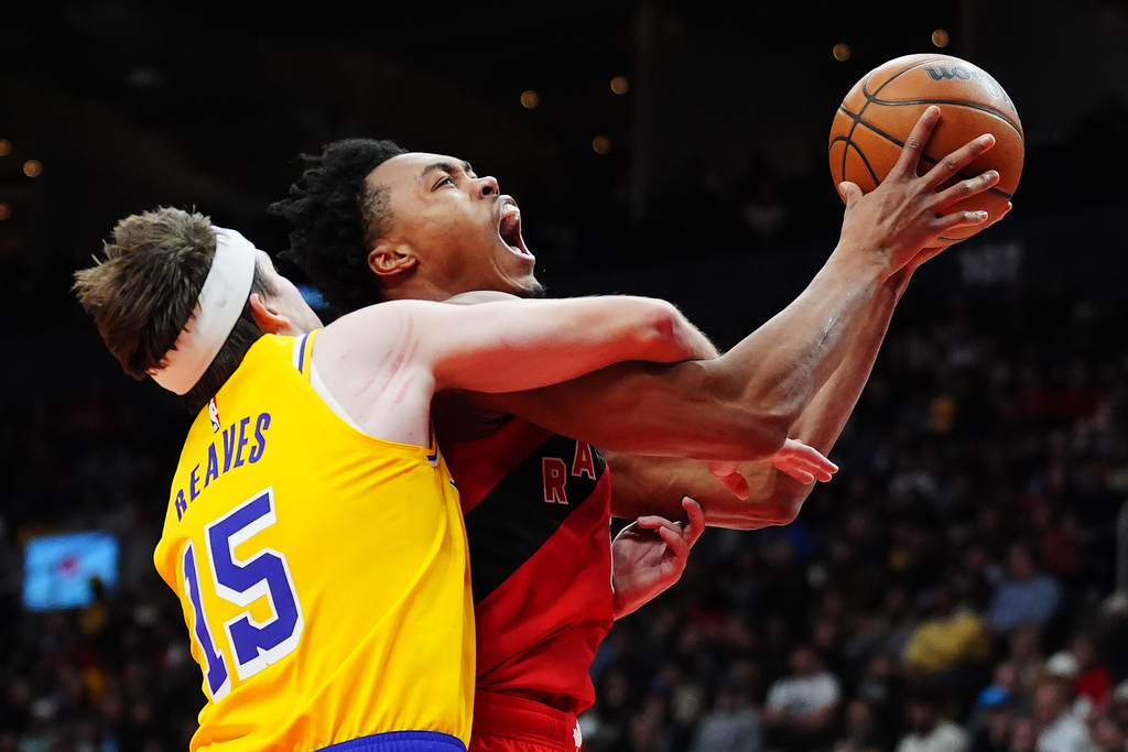 Los Angeles Lakers' Austin Reaves (15) fouls Toronto Raptors' Scottie Barnes (4) during first half NBA basketball action in Toronto on Thursday, Dec. 4, 2025. (Frank Gunn/The Canadian Press via AP)