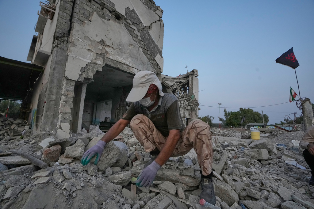 A volunteer searches through the rubble of Shajareh Tayyebeh school, shattered by a U.S. airstrike on Feb. 28, in Minab, southern Iran, Monday, Sept. 7, 2026. (AP Photo/Vahid Salemi)