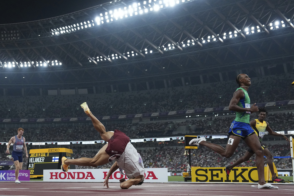 Qatar's Bassem Hemeida, left, falls during a men's 400 meters hurdles semifinal at the World Athletics Championships in Tokyo, Wednesday, Sept. 17, 2025. (AP Photo/Bernat Armangue)