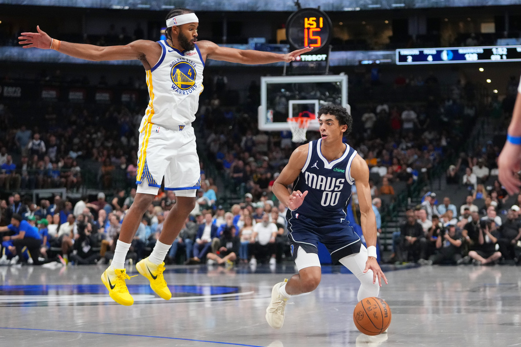 Dallas Mavericks guard Max Christie (00) prepares to shoot a basket as Golden State Warriors guard Moses Moody (4) defends during overtime of an NBA basketball game Monday, March 23, 2026, in Dallas. (AP Photo/Julio Cortez)