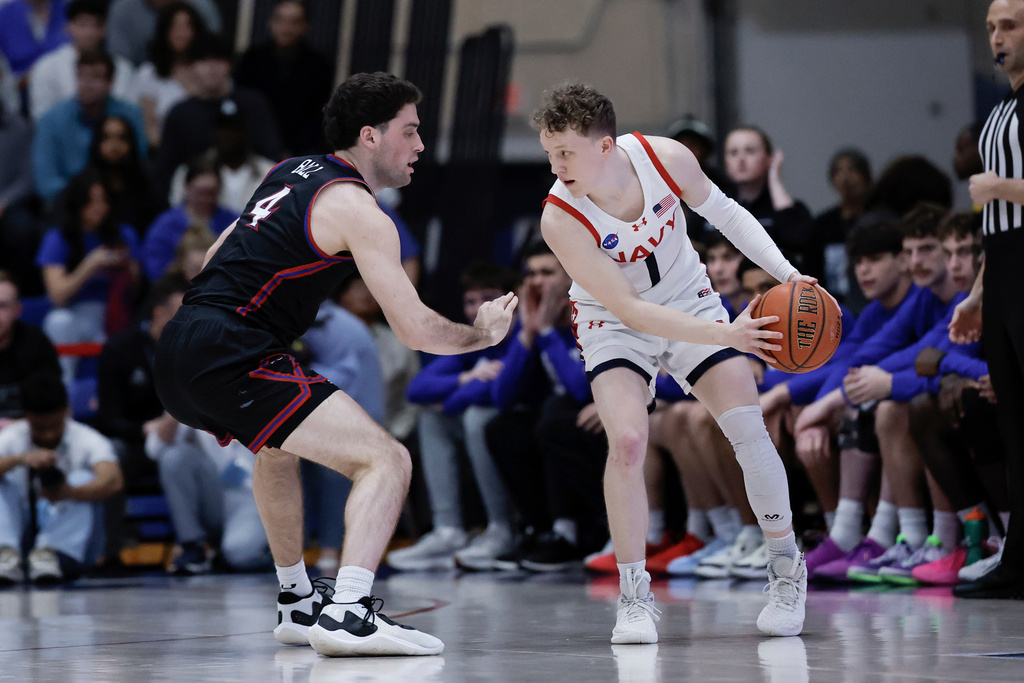 FILE - Navy guard Austin Benigni (1) controls the ball against American guard Lincoln Ball (4) during the first half of an NCAA college basketball game in the championship of the Patriot League tournament, Wednesday, March 12, 2025, in Washington. (AP Photo/Terrance Williams, File)