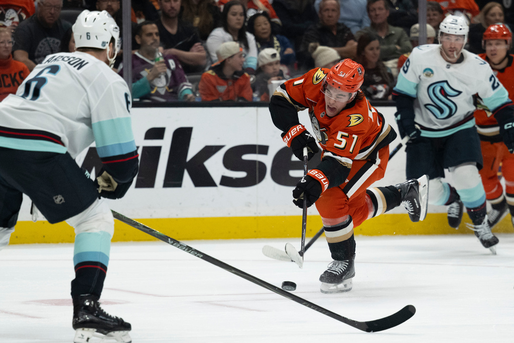 Anaheim Ducks defenseman Olen Zellweger (51) shoots as Seattle Kraken defenseman Adam Larsson (6) defends during the first period of an NHL hockey game, Tuesday, Feb. 3, 2026, in Anaheim, Calif. (AP Photo/Kyusung Gong)