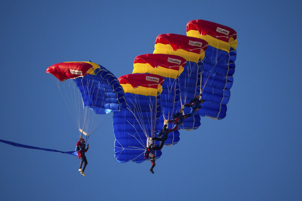 Romanian paratroopers glide above the Aurel Vlaicu airport, on the first day of the Bucharest International Air Show, BIAS, in Bucharest, Romania, Saturday, Aug. 30, 2025. (AP Photo/Andreea Alexandru)