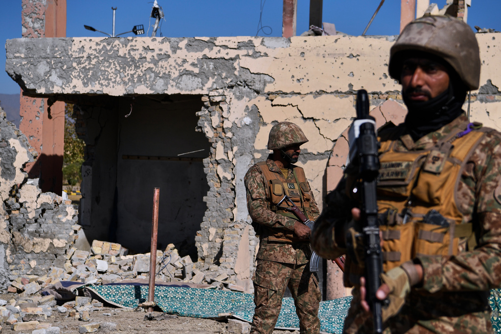 Army soldiers stands guard next to a damaged building of an army-run cadet college that was assaulted by militants on Monday, in Wana, a city in the northwestern Pakistani district South Waziristan bordering with Afghanistan, Thursday, Nov. 13, 2025. (AP Photo/Ahsan Shahzad)