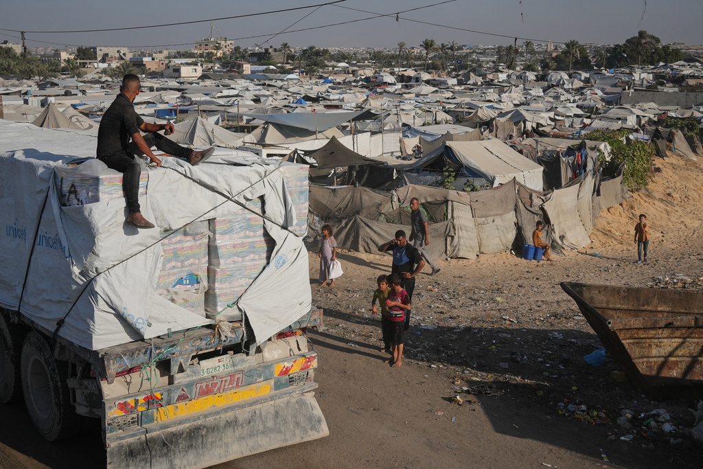 Trucks carrying aid drive through Khan Younis, southern Gaza Strip, Sunday, Nov. 2, 2025. (AP Photo/Jehad Alshrafi)