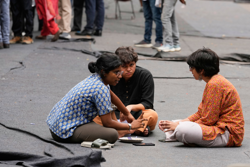 Volunteers of the Cockroach Janta Party sit and talk during a protest demanding the resignation of Education Minister Dharmendra Pradhan over alleged examination irregularities and repeated paper leaks, in New Delhi, India, on July 10, 2026. (AP Photo/Manish Swarup)