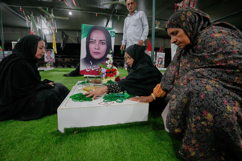 Fatemeh Barani, second from right, mourns at the grave of her daughter, Nasim Neyestani, a second-grade teacher killed in a U.S. airstrike on Shajareh Tayyebeh school on Feb. 28, in a section of a cemetery set aside for those killed at the school in Minab, southern Iran, Monday, Sept. 7, 2026. (AP Photo/Vahid Salemi)