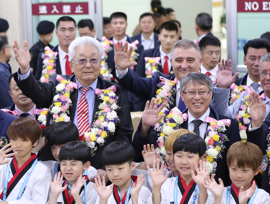 FILE - Then North Korea's International Olympic Committee, IOC, member Chang Ung, middle row left, waves with officials of International Taekwondo Federation for the media upon their arrival at Gimpo International Airport in Seoul, South Korea, on June 23, 2017. (AP Photo/Lee Jin-man, File)