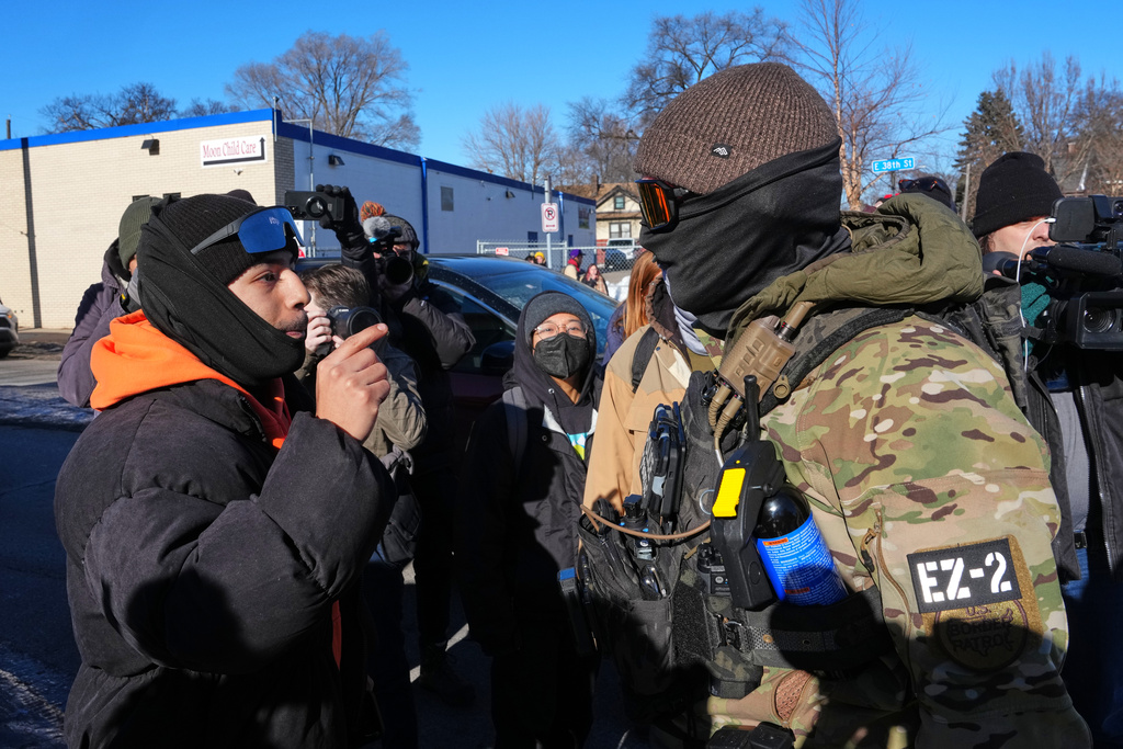 A person confronts a U.S. Border Patrol officer Wednesday, Jan. 14, 2026, in Minneapolis. (AP Photo/Adam Gray)