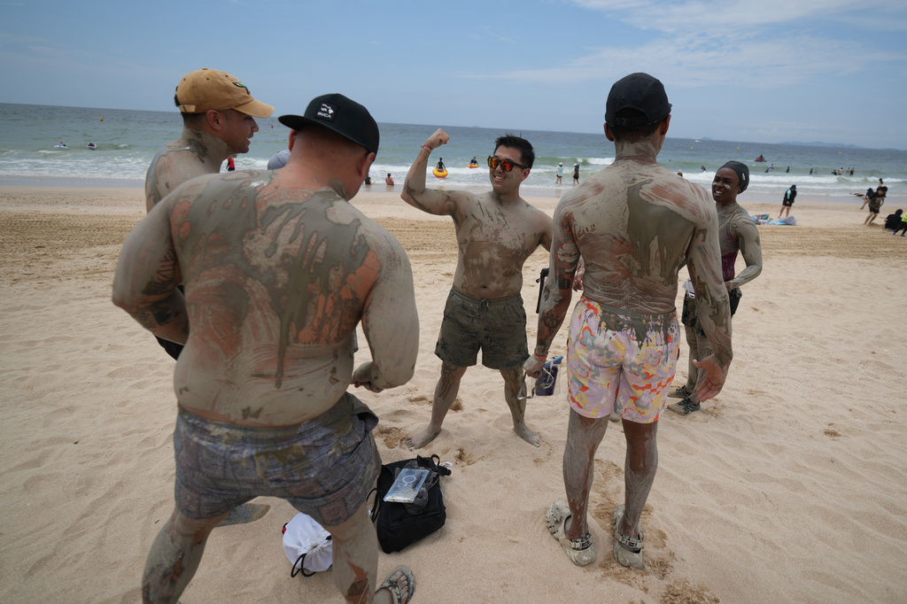 Visitors covered in a mud play during the Boryeong Mud Festival at a beach in Boryeong, South Korea, Saturday, July 25, 2026. (AP Photo/Lee Jin-man)