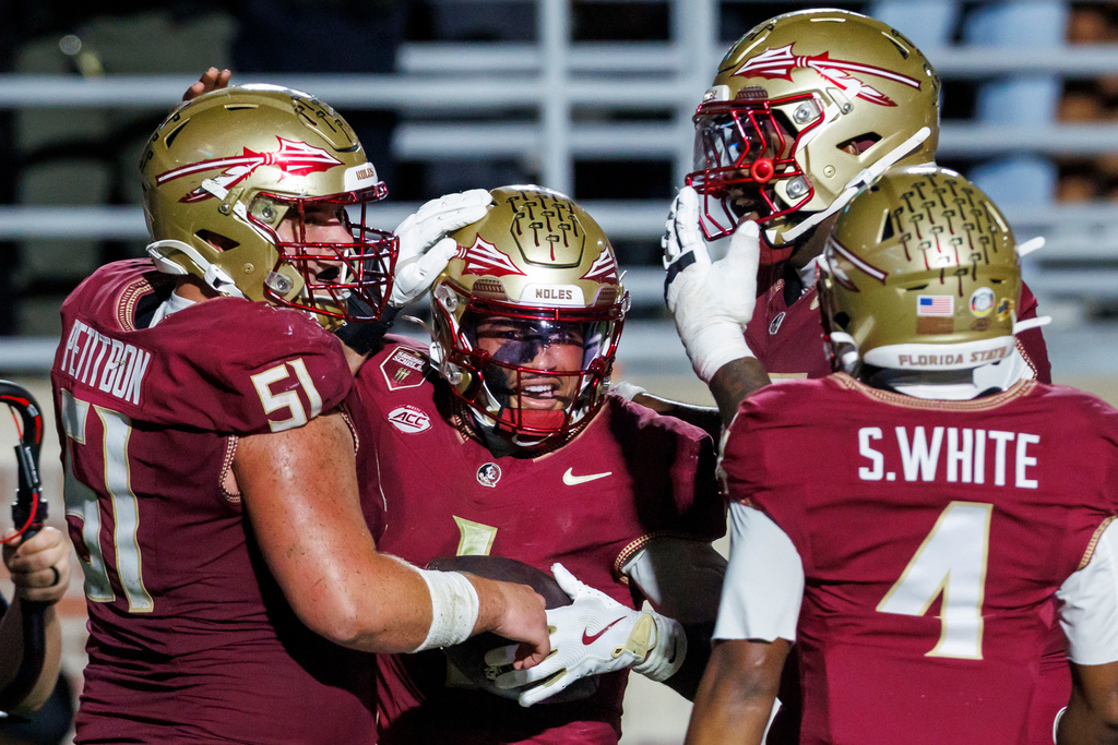 Florida State quarterback Tommy Castellanos, center, celebrates after his second-half touchdown against Virginia Tech with offensive lineman Luke Petitbon (51), offensive lineman Micah Pettus, top right, and wide receiver Squirrel White (4) during an NCAA college football game, Saturday, Nov. 15, 2025, in Tallahassee, Fla. (AP Photo/Colin Hackley)