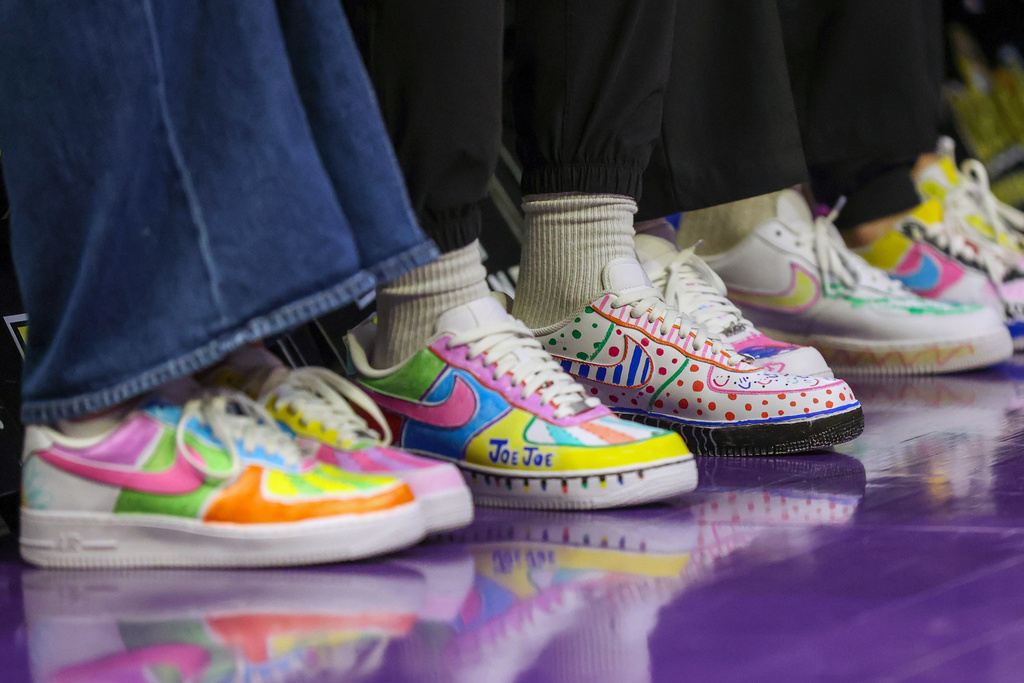 Members of the LSU coaching staff sport shoes that were decorated by patients of the children's unit inside of Lady of the Lake Hospital in the first half of an NCAA college basketball game between Texas-Arlington and LSU in Baton Rouge, La., Sunday, Dec. 21, 2025. (AP Photo/Peter Forest)