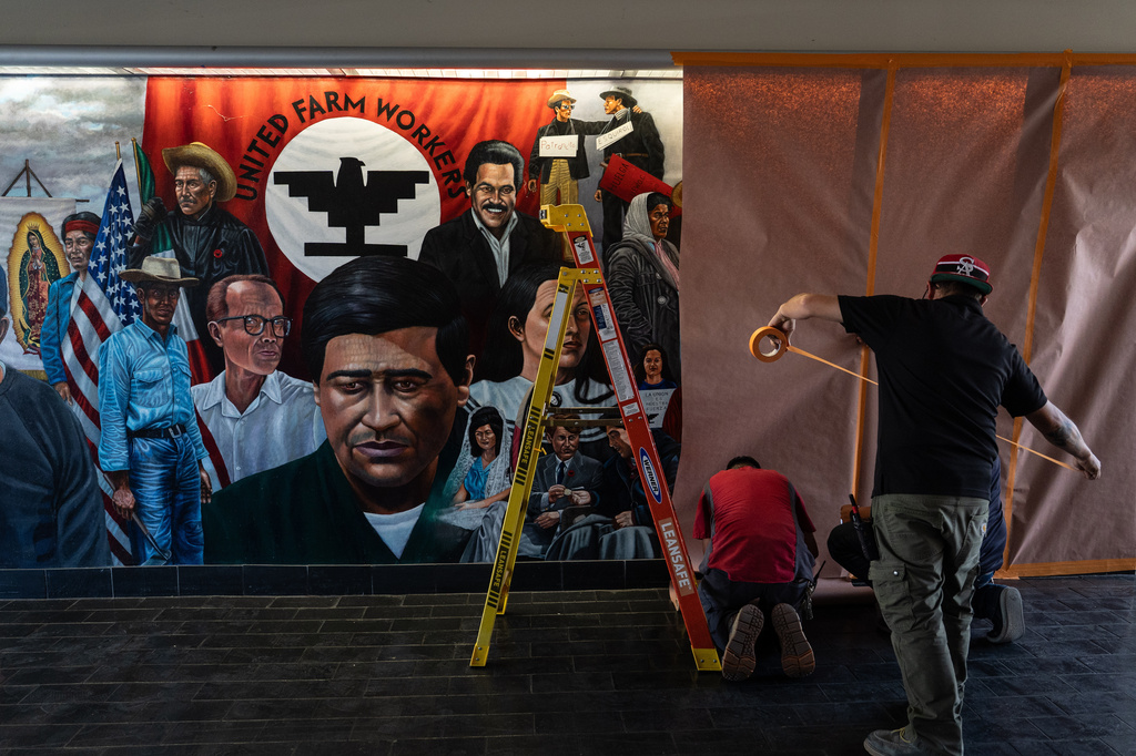 FILE - Workers cover a mural by Emigdio Vasquez featuring Cesar Chavez and other figures at Santa Ana College in Santa Ana, Calif., Thursday, March 19, 2026. (AP Photo/Jae C. Hong, file)