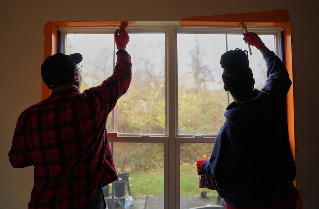 A group from the Neighborhood Resilience Project, an Orthodox social service agency connected to St. Moses the Black Orthodox Church, paints a home in Clairton, Pa., as part of the organization's community-building programs, Monday, Nov. 24, 2025. (AP Photo/Jessie Wardarski)
