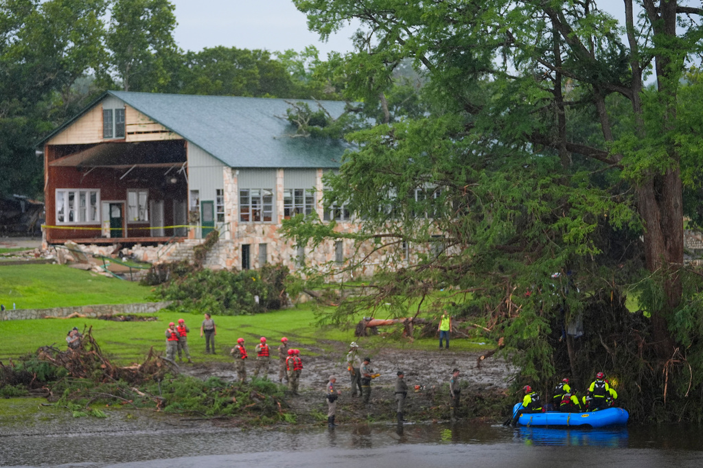 FILE - Rescue workers are seen on land and on a boat as they search for missing people near Camp Mystic along the Guadalupe River after a flash flood swept through the area Sunday, July 6, 2025, in Hunt, Texas. (AP Photo/Julio Cortez, File)