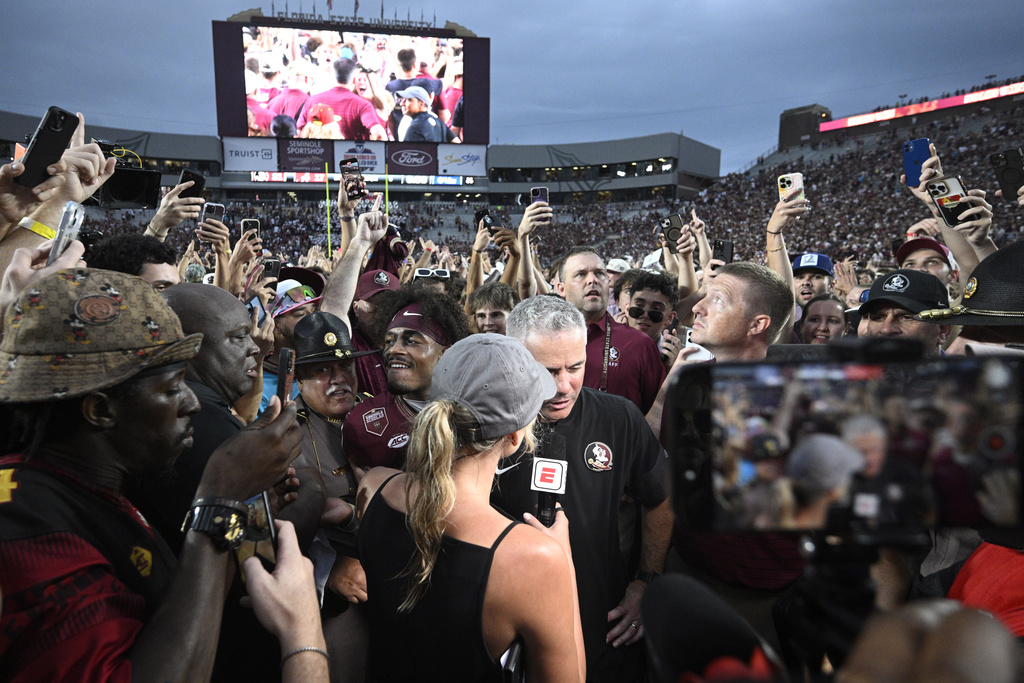 Florida State head coach Mike Norvell, center, is interviewed after a win against Alabama in an NCAA college football game, Saturday, Aug. 30, 2025, in Tallahassee, Fla. (AP Photo/Phelan M. Ebenhack)