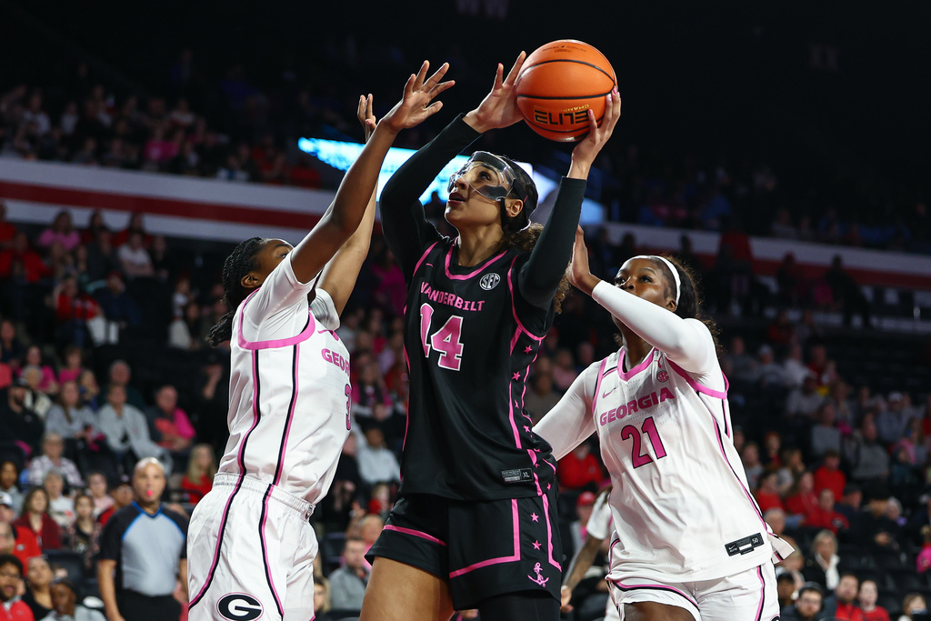Vanderbilt forward Aiyana Mitchell (14) shoots against Georgia guard Dani Carnegie, left and center Aicha Ndour, right, during the first half of an NCAA college basketball game, Sunday, Feb. 15, 2026, in Athens, Ga. (AP Photo/Colin Hubbard)
