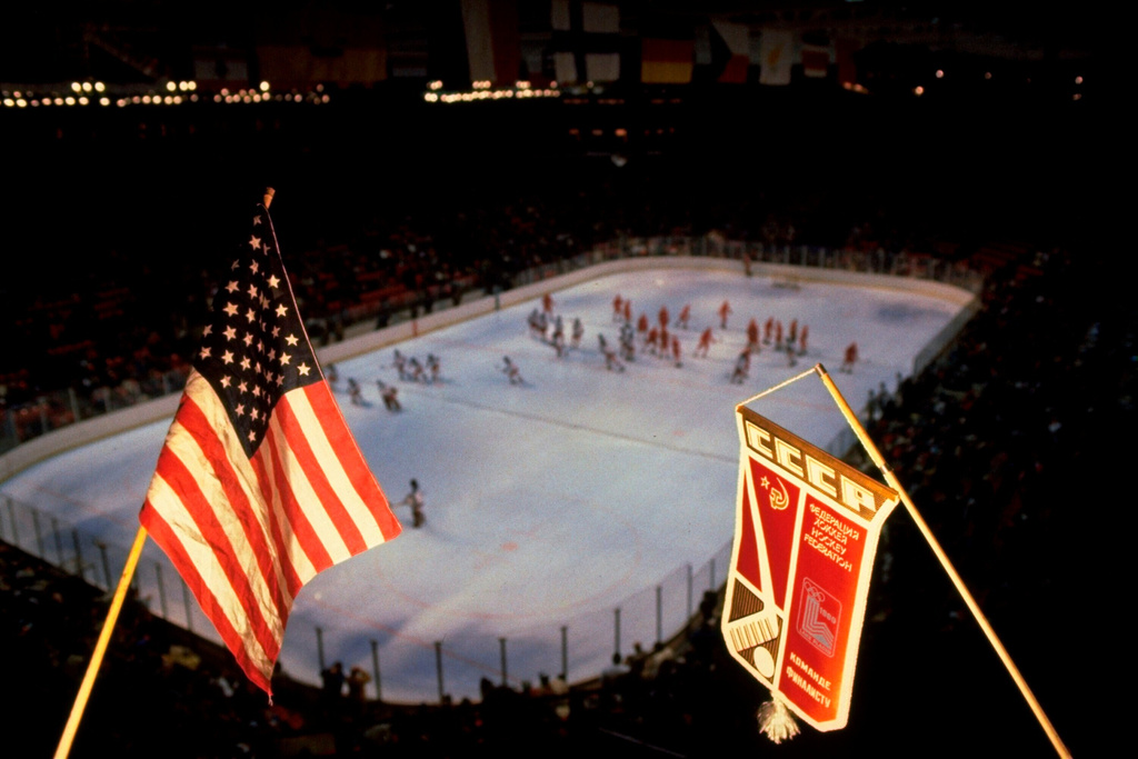 FILE - In this Feb. 22, 1980, file photo, an American flag and Soviet team banner are shown above the hockey rink where the the United States and Soviets played a medal round hockey match at the 1980 Winter Olympics in Lake Placid, N.Y. (AP Photo/File)