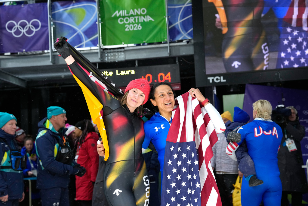 Germany's silver medalist Laura Nolte, left, and United States' gold medalist Elana Meyers Taylor, right, celebrate at the finish after the women's monobob competition at the 2026 Winter Olympics, in Cortina d'Ampezzo, Italy, Monday, Feb. 16, 2026. (AP Photo/Alessandra Tarantino)