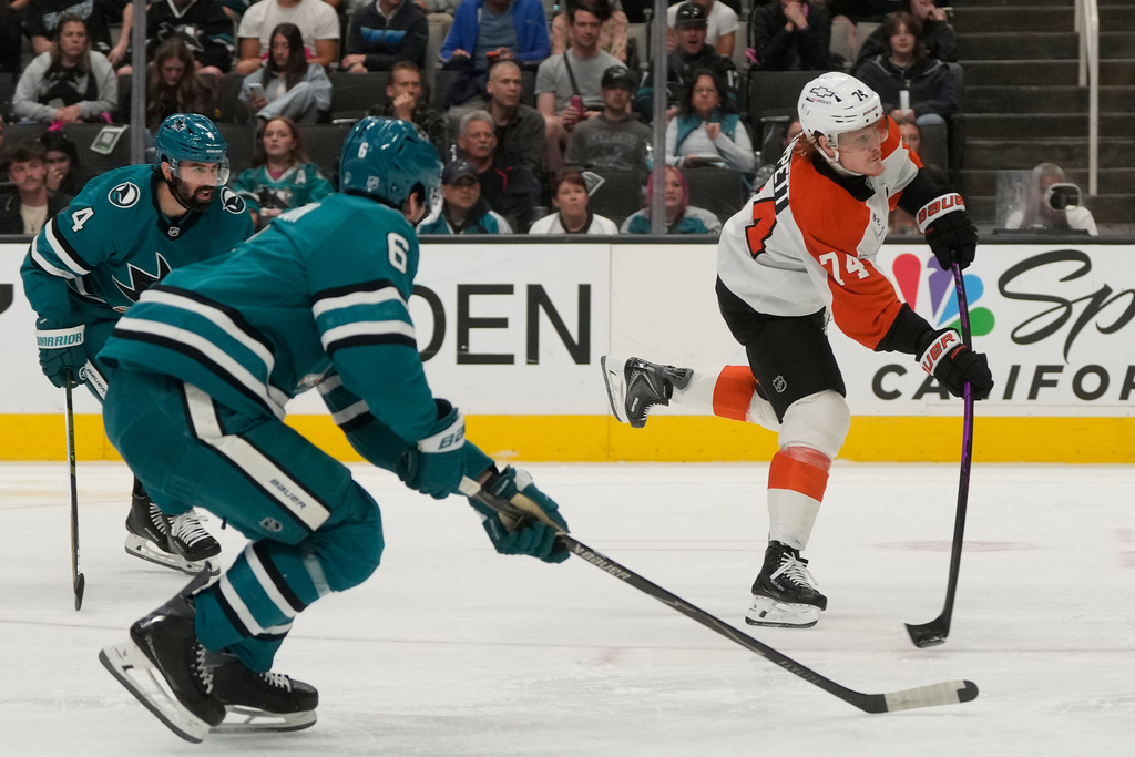 Philadelphia Flyers right wing Owen Tippett, right, scores a goal next to San Jose Sharks defenseman Nick Leddy (4) and defenseman Sam Dickinson (6) during the second period of an NHL hockey game in San Jose, Calif., Saturday, March 21, 2026. (AP Photo/Jeff Chiu)