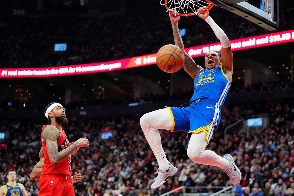 Golden State Warriors guard Will Richard (3) slam-dunks as Toronto Raptors forward Brandon Ingram, left, looks on during first-half NBA basketball game action in Toronto, Sunday, Dec. 28, 2025. (Frank Gunn/The Canadian Press via AP)