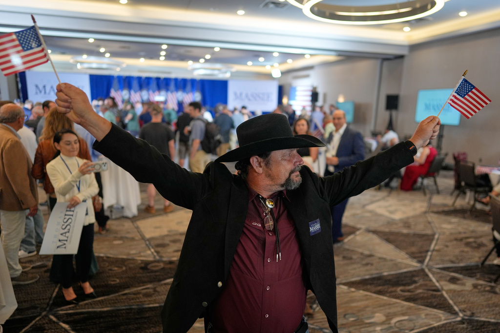 Eddie Van Zandt holds flags during an election night watch party for Rep. Thomas Massie, R-Ky., at the Marriott Cincinnati Airport, Tuesday, May 19, 2026, in Hebron, Ky. (AP Photo/Carolyn Kaster)