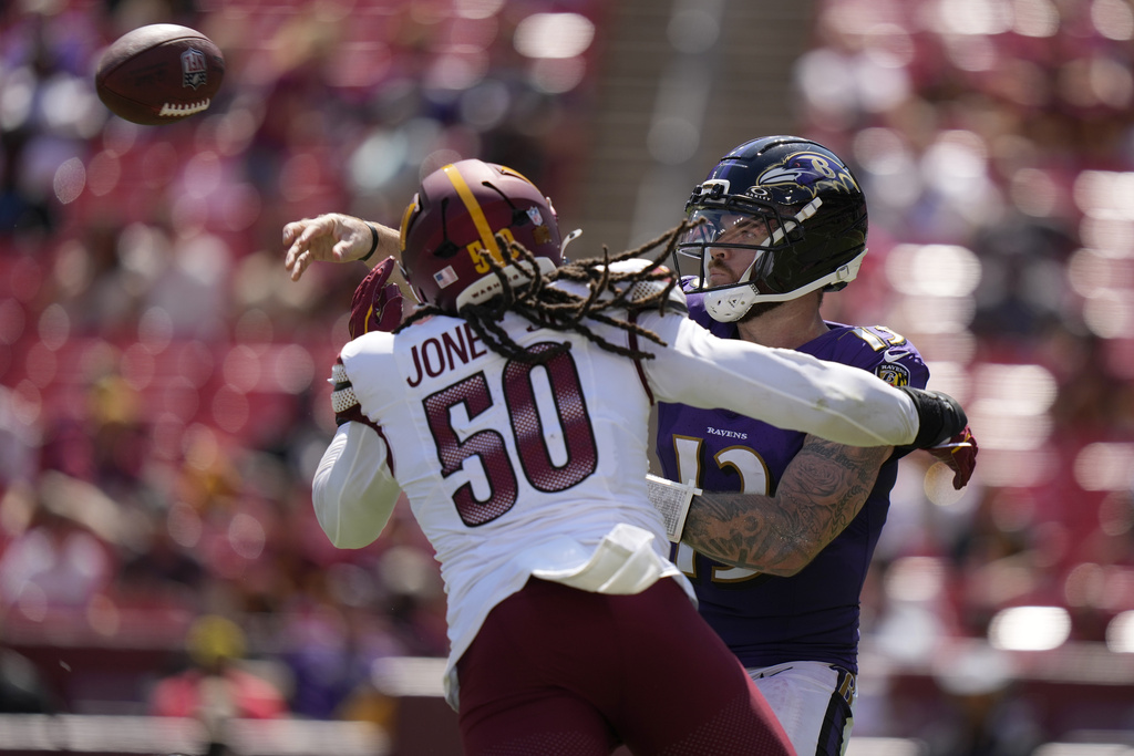Baltimore Ravens quarterback Devin Leary, right, throws under pressure from Washington Commanders defensive end Andre Jones Jr. (50) during the second half of a preseason NFL football game Saturday, Aug. 23, 2025, in Landover, Md. (AP Photo/Stephanie Scarbrough)
