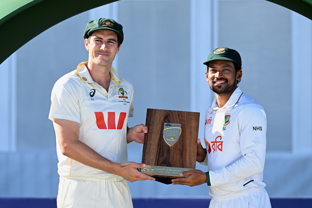 Australian captain Pat Cummins, left, and Bangladesh's captain Najmul Hossain Shanto pose following presentations on the second day of their second cricket test match in Mackay, Australia, Sunday, Aug. 23, 2026. (Dave Hunt/AAP Image via AP)