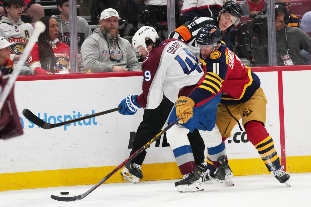 Colorado Avalanche defenseman Samuel Girard (49) and Florida Panthers right wing MacKie Samoskevich (11) compete for the puck during the second period of an NHL hockey game, Sunday, Jan. 4, 2026, in Sunrise, Fla. (AP Photo/Lynne Sladky)