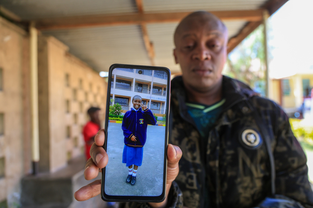 John Muiruri, father of Nicole Muiruri, who died in the fire at Utumishi Girls Academy, shows a photo of his daughter as he waits for body identification and DNA testing at Naivasha Funeral Home in Naivasha Town, Rift Valley region, Kenya, Friday, May 29, 2026. (AP Photo/Andrew Kasuku)