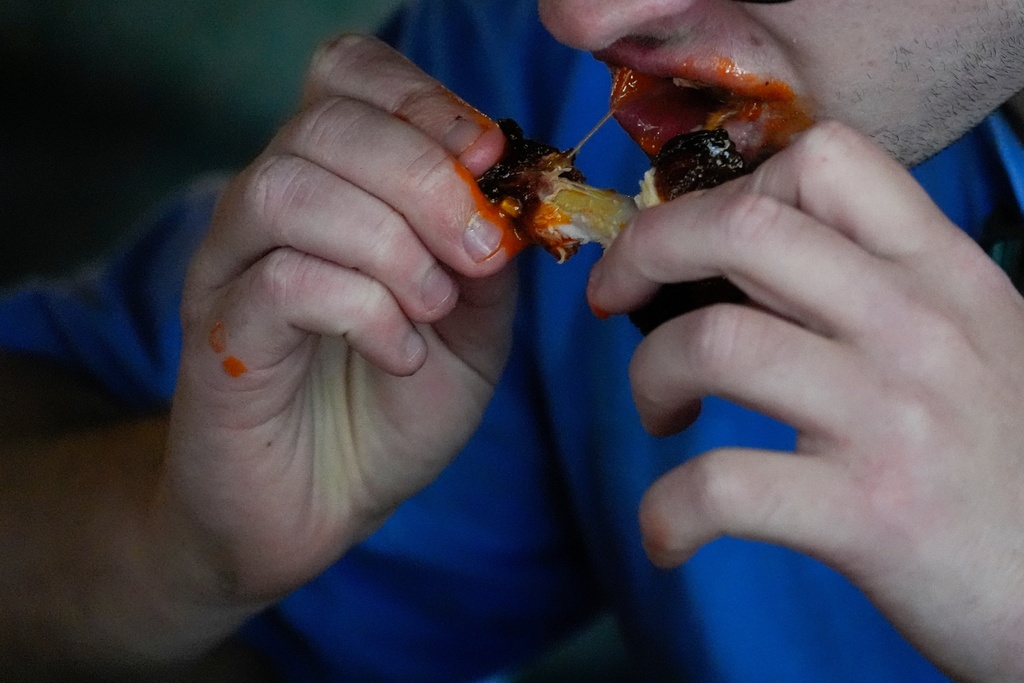 FILE - A man eats a chicken wing June 12, 2024, at a barbecue restaurant in Cincinnati. (AP Photo/Joshua A. Bickel, File)