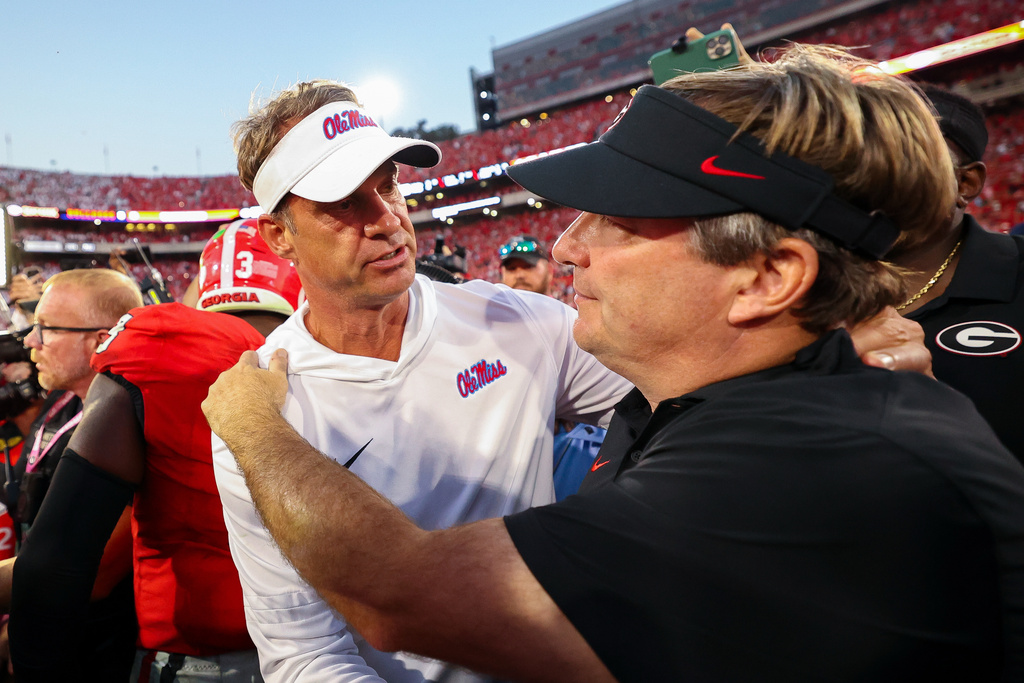 FILE - Mississippi head coach Lane Kiffin, left, and Georgia head coach Kirby Smart, right, embrace at midfield after an NCAA college football game, Saturday, Oct. 18, 2025, in Athens, Ga. (AP Photo/Colin Hubbard, File)